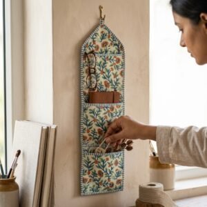 An interior room setup showing the Floral Quilted Wall Hanging Organizer near a wooden desk, showcasing its space-saving capacity and elegant patterned office home pocketbook style.