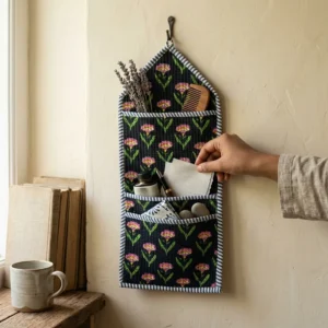 An interior room setup showing the Floral Quilted Wall Hanging Organizer near a wooden office desk, showcasing its space-saving capacity and elegant patterned office home pocketbook style.
