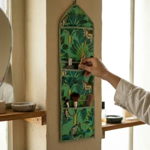 An interior room setup showing the Green Fabric Wall Hanging Organizer near a wooden office desk, showcasing its space-saving capacity and elegant patterned office pocketbook style.