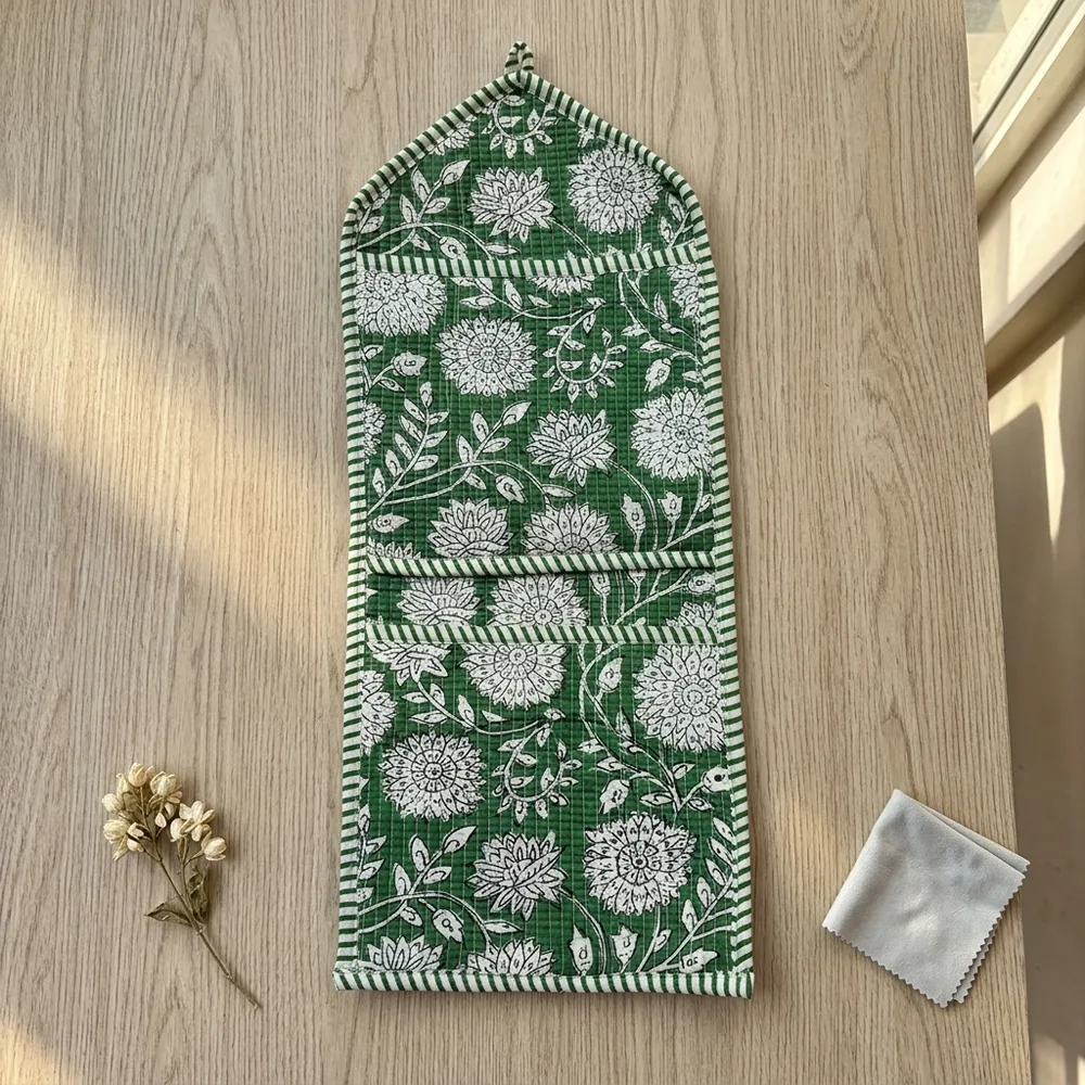 Close-up of the handcrafted green botanical print detailing, dense quilted stitching texture lines, robust pocket seam attachments, and clean pocket opening on the cotton pocket storage.