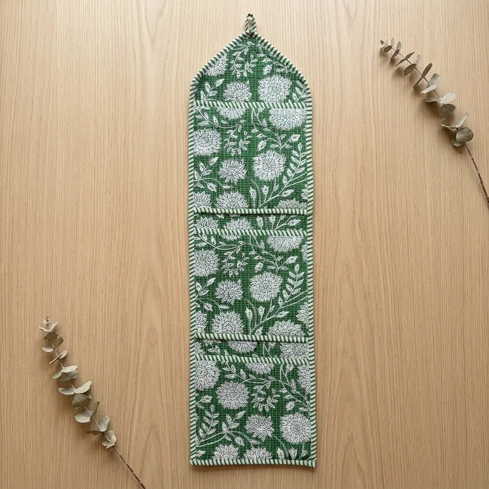 Close-up of the handcrafted green botanical print detailing, dense quilted stitching texture lines, robust pocket seam attachments, and clean pocket opening on the cotton pocket storage.