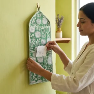 Green Floral Quilted Wall Hanging Organizer displaying the multi-pocket vertical sorting slots with the traditional emerald block print artisan design hung securely on an entryway wall.