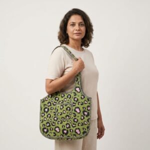 A shopper carrying the Green Tiger Quilted Shoulder Tote Bag by the wide straps, showcasing its generous packing capacity and elegant scoop handbag style at an outdoor farmers market.