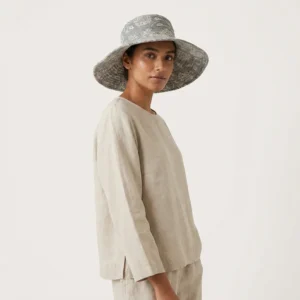 Close-up of the handcrafted grey floral print detailing, dense quilted tracking stitching lines, and neat edge trim on the reversible side of the summer travel headwear.