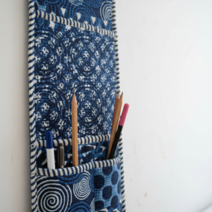 Close-up of the handcrafted deep blue geometric pattern detailing, soft quilted construction lines, heavy-duty stitching borders, and clean empty pocket entry slot on an Indian cotton wall organizer.