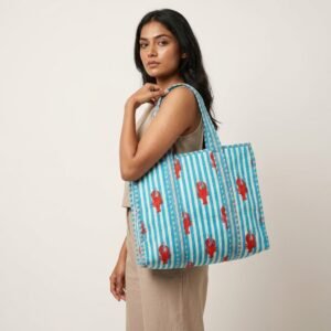A shopper carrying the Lobster Print Quilted Shoulder Tote Bag by the wide straps, showcasing its generous packing capacity and elegant bohemian accessory style at an outdoor farmers market.