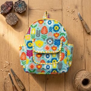 Close-up of the handcrafted colorful block print floral detailing, dual open side pockets, zipped front storage pouch, and dense quilted stitching texture lines on an Indian cotton mini travel rucksack.