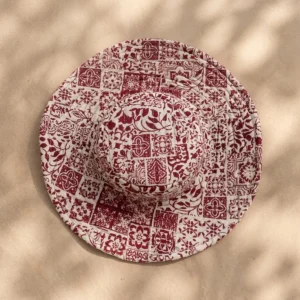 Close-up of the handcrafted maroon floral print detailing, dense quilted tracking stitching lines, and neat edge trim on the reversible side of the summer travel headwear.