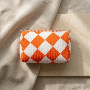 Close-up of the handcrafted orange diamond geometric print detailing, dense quilted stitching texture lines, robust zipper attachment, and clean water-resistant lining on the cotton cosmetic pouch.
