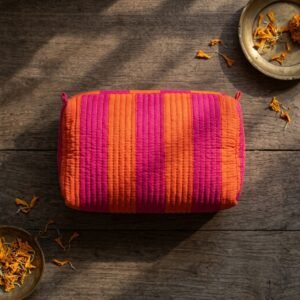 Close-up of the largest case in the Orange Pink Striped Quilted Toiletry Bag Set opened to reveal the clean protective interior lining, smooth zipper track, and soft quilted horizontal stitching texture.