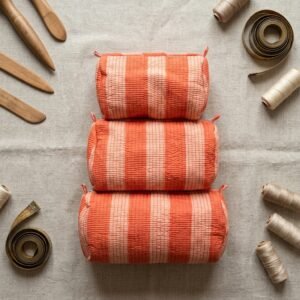 Close-up of the largest case in the Orange Striped Quilted Toiletry Bag Set opened to reveal the clean protective interior lining, smooth zipper track, and soft quilted horizontal stitching texture.
