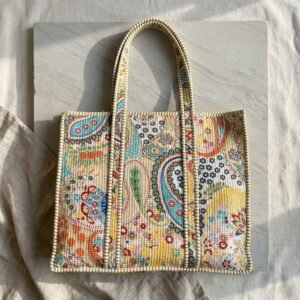 Close-up of the handcrafted paisley print detailing, dense quilted stitching texture lines, robust handle strap attachments, and clean inner layout on an Indian cotton travel purse.