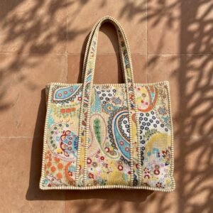 Close-up of the handcrafted paisley print detailing, dense quilted stitching texture lines, robust handle strap attachments, and clean inner layout on an Indian cotton travel purse.