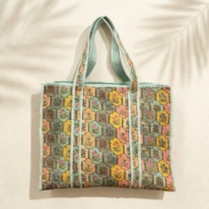 Close-up of the handcrafted pastel botanical print detailing, dense quilted stitching texture lines, robust handle strap attachments, and clean inner layout on an Indian cotton travel purse.