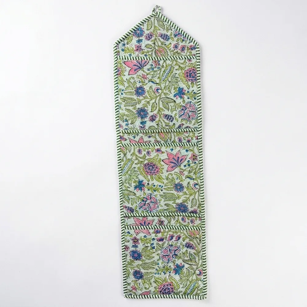 Close-up of the handcrafted pastel botanical print detailing, dense quilted stitching texture lines, robust pocket seam attachments, and clean pocket opening on the cotton pocket storage.