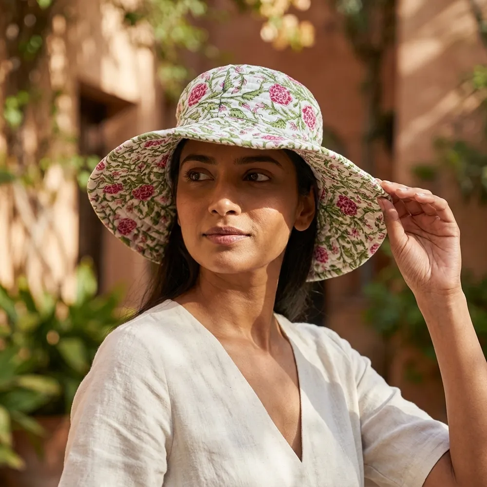 A sunny outdoor display featuring a person wearing the Pink Floral Quilted Cotton Sun Hat during a vacation trip, highlighting its comfortable universal fit and bohemian style.