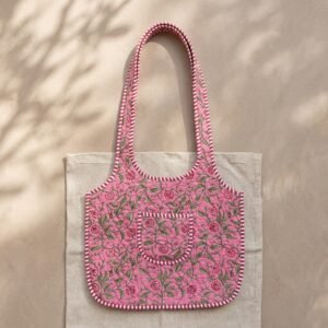Close-up of the handcrafted pink botanical print detailing, dense quilted stitching texture lines, robust handle strap attachments, and clean inner layout on an Indian cotton market purse.
