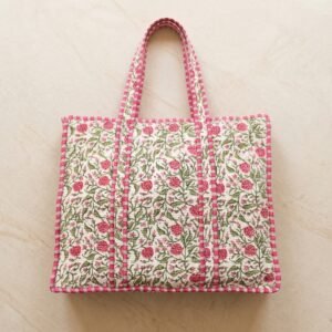 Close-up of the handcrafted pink botanical print detailing, dense quilted stitching texture lines, robust handle strap attachments, and clean inner layout on an Indian cotton travel purse.