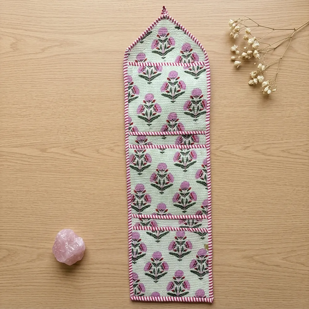 Close-up of the handcrafted pink botanical print detailing, dense quilted stitching texture lines, robust pocket seam attachments, and clean pocket opening on the cotton pocket storage.