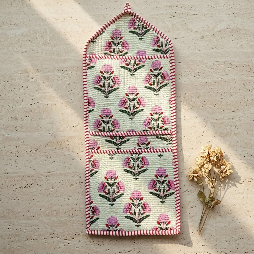 Close-up of the handcrafted pink botanical print detailing, dense quilted stitching texture lines, robust pocket seam attachments, and clean pocket opening on the cotton pocket storage.