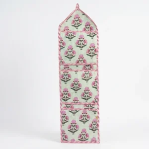 Close-up of the handcrafted pink botanical print detailing, dense quilted stitching texture lines, robust pocket seam attachments, and clean pocket opening on the cotton pocket storage.
