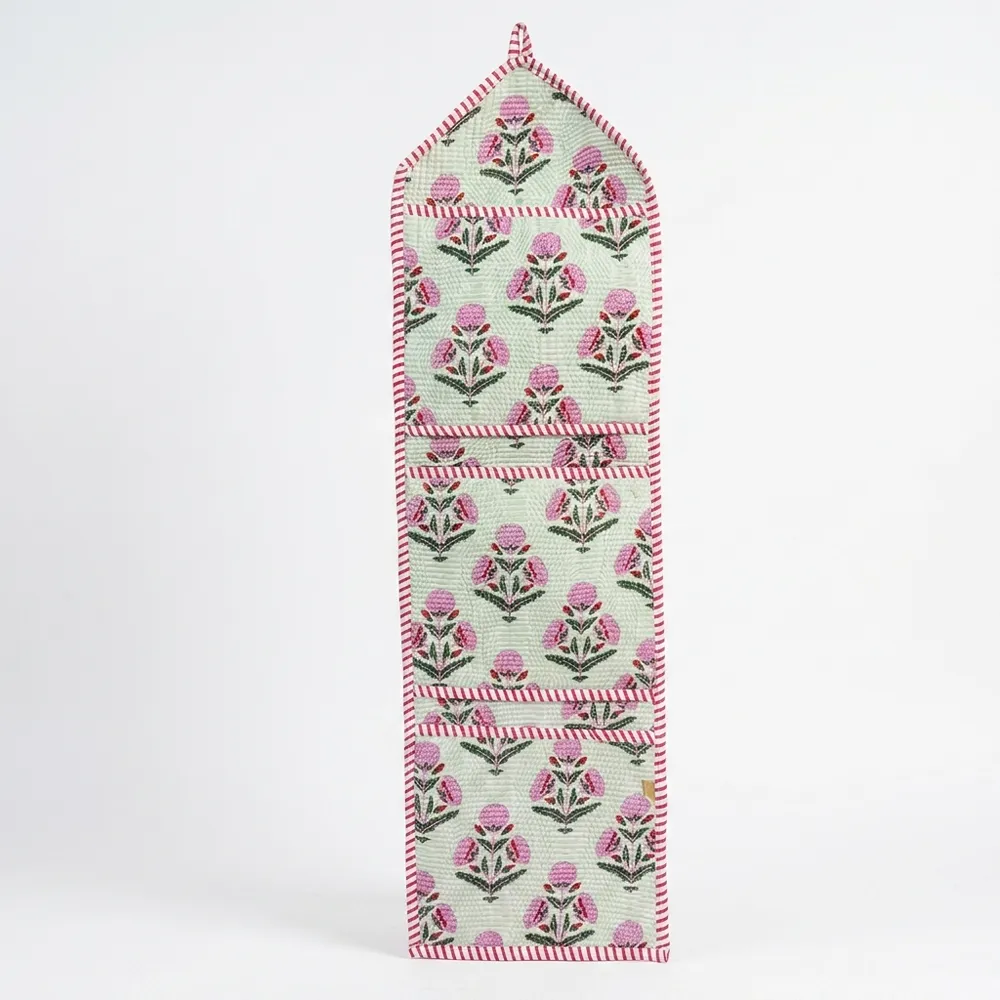 Close-up of the handcrafted pink botanical print detailing, dense quilted stitching texture lines, robust pocket seam attachments, and clean pocket opening on the cotton pocket storage.