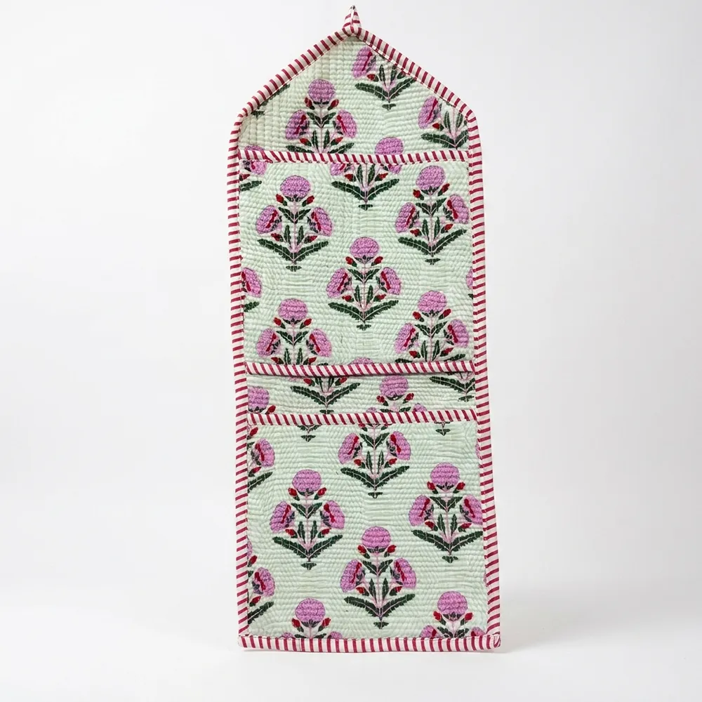 Close-up of the handcrafted pink botanical print detailing, dense quilted stitching texture lines, robust pocket seam attachments, and clean pocket opening on the cotton pocket storage.