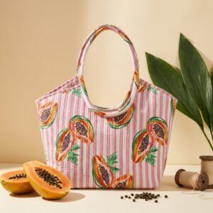 Close-up of the handcrafted papaya tropical fruit print detailing, dense quilted stitching texture lines, robust handle strap attachments, and clean inner layout on an Indian cotton travel purse.