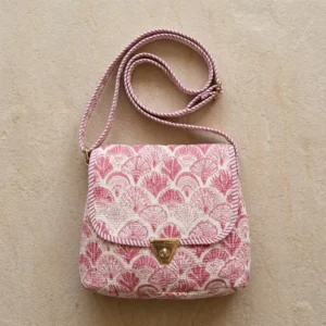 Close-up of the handcrafted pink scallop wave print detailing, dense quilted tracking lines, robust zipper closure, and clean seam line on the floral tropical travel handbag.