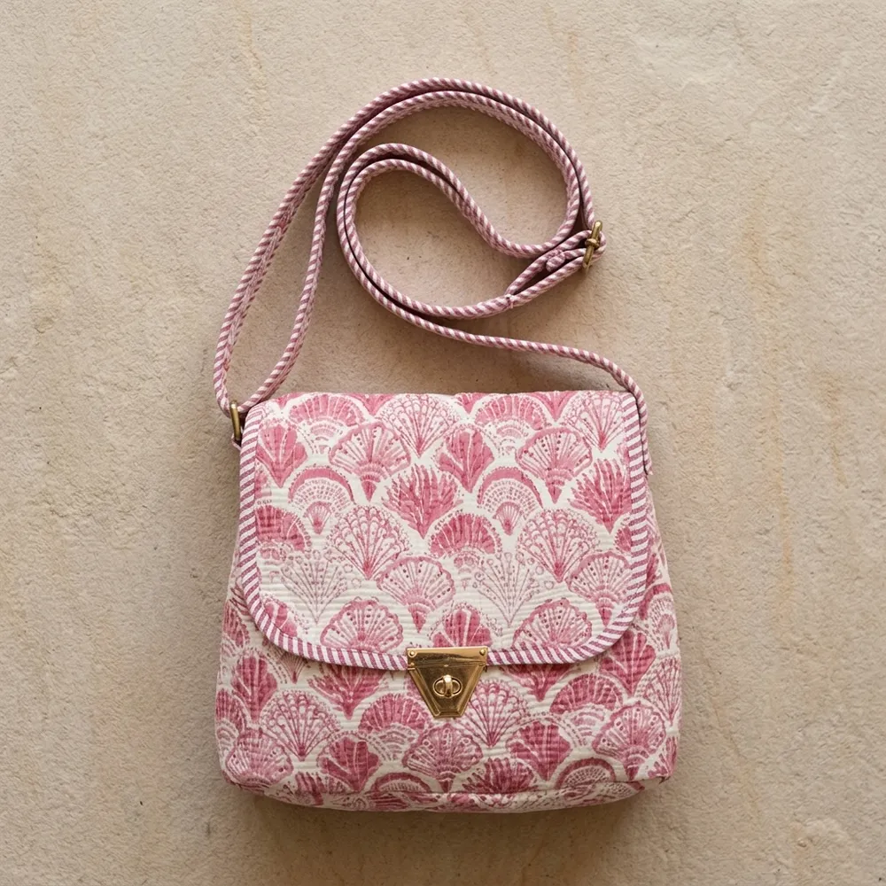 Close-up of the handcrafted pink scallop wave print detailing, dense quilted tracking lines, robust zipper closure, and clean seam line on the floral tropical travel handbag.