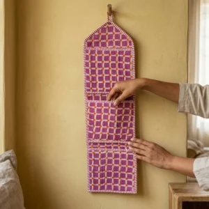 An interior room setup showing the Purple Plaid Quilted Wall Hanging Organizer near a wooden office desk, showcasing its space-saving capacity and elegant patterned office home pocketbook style.