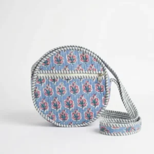 A model wearing the Blue Floral Quilted Crossbody Bag across the torso, showcasing its compact packing capacity and elegant bohemian accessory style during an outdoor music festival.