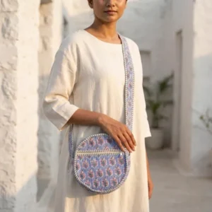 Close-up of the handcrafted blue botanical blossom print detailing, dense quilted stitching texture lines, robust handle strap attachments, and secure top zipper slider on an Indian cotton circle purse.