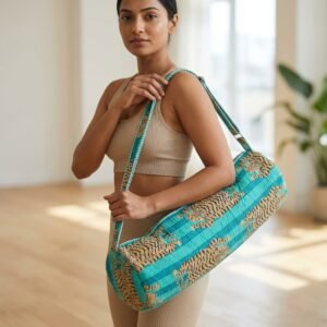 A fitness enthusiast carrying the Quilted Cotton Tiger Print Yoga Mat Bag over the shoulder by the wide strap, showcasing its long profile and classic bohemian accessory style while heading to a beach yoga class.
