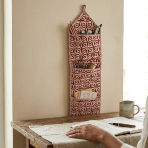 Close-up of the handcrafted red and maroon print detailing, dense quilted stitching texture lines, robust pocket seam attachments, and clean pocket opening on the cotton pocket storage.