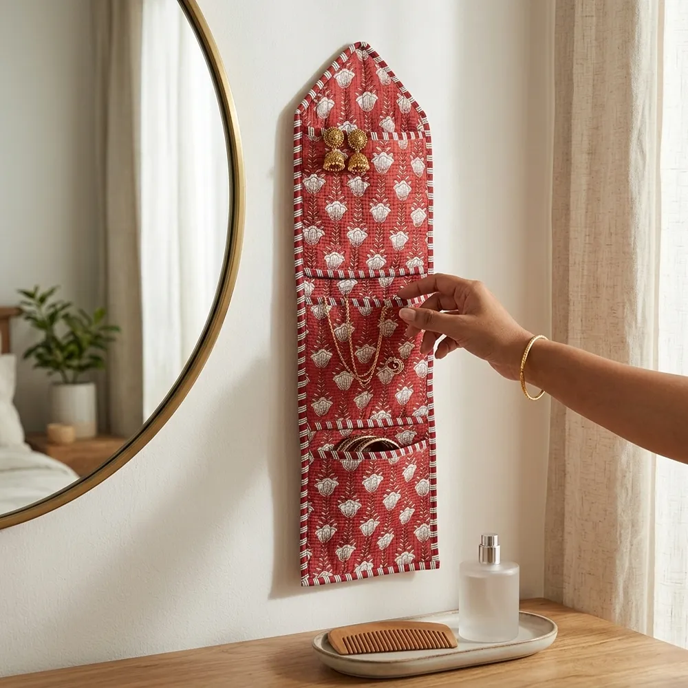 An interior room setup showing the Red Floral Quilted Wall Hanging Organizer near a wooden office desk, showcasing its space-saving capacity and elegant patterned office home pocketbook style.