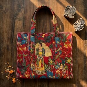 Close-up of the handcrafted artistic portrait print detailing, vibrant red background accents, dense quilted stitching texture lines, and robust handle strap attachments on an Indian cotton carryall tote.