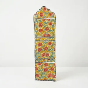 Close-up of the handcrafted yellow botanical print detailing, dense quilted stitching texture lines, robust pocket seam attachments, and clean pocket opening on the cotton pocket storage.