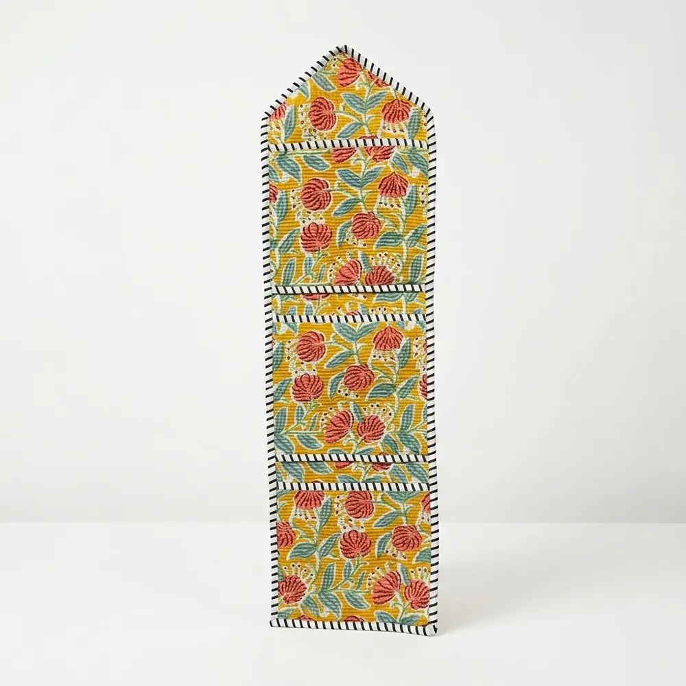 Close-up of the handcrafted yellow botanical print detailing, dense quilted stitching texture lines, robust pocket seam attachments, and clean pocket opening on the cotton pocket storage.