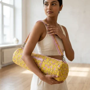 Yellow Floral Quilted Cotton Yoga Mat Bag showing the cylindrical crossbody carrier design with the handcrafted yellow botanical block print pattern and full-length zipper closure.