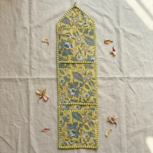 Close-up of the handcrafted yellow botanical print detailing, dense quilted stitching texture lines, robust pocket seam attachments, and clean pocket opening on the cotton pocket storage.