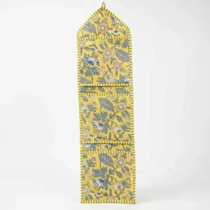 Close-up of the handcrafted yellow botanical print detailing, dense quilted stitching texture lines, robust pocket seam attachments, and clean pocket opening on the cotton pocket storage.