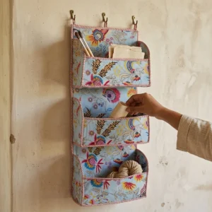 Handmade quilted cotton hanging wall organizer with blue floral print and five tiered storage pockets