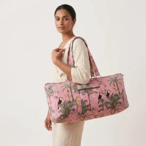An outdoor studio scene featuring the Pink Zebra Quilted Cotton Yoga Mat Bag held by its shoulder straps, highlighting its lightweight carrying convenience and bohemian style.